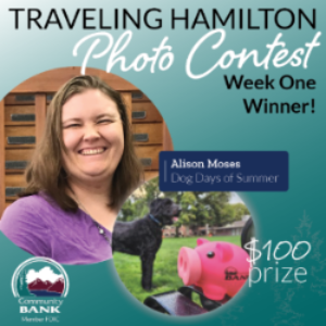 Alison Moses with her winning photo of Hamilton posed with her dog in the background.